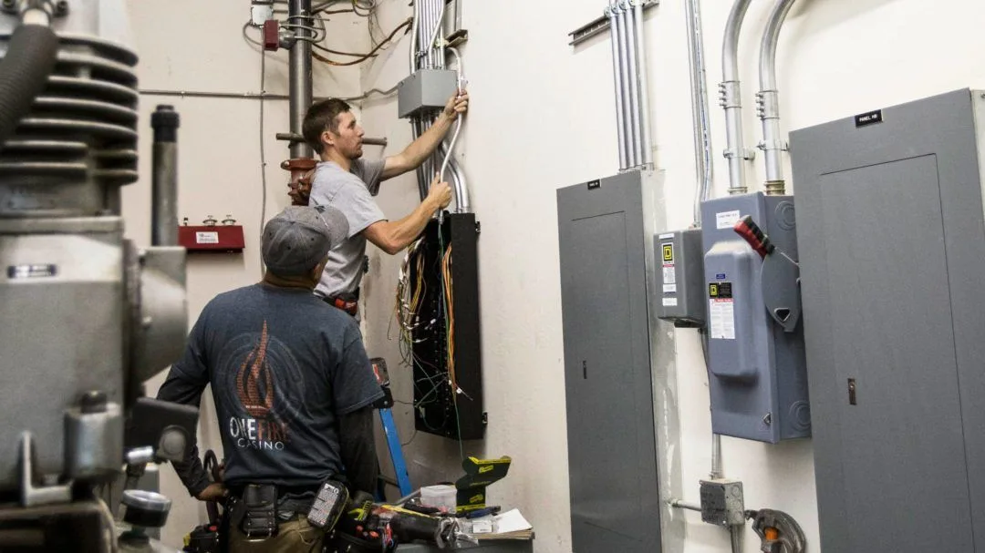 Electricians working on electrical conduit and equipment